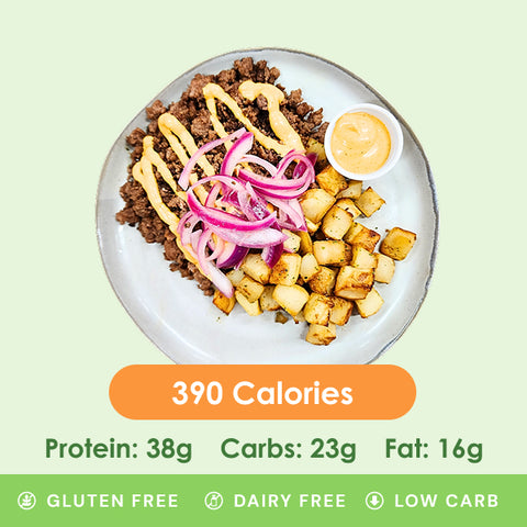 A flavorful bison burger bowl featuring seasoned ground bison, crispy roasted potatoes, and thinly sliced red onions, with a side of creamy sauce and nutritional information.