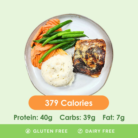 A perfectly cooked blackened Cajun salmon fillet served with tender green beans and creamy mashed potatoes, displaying its nutritional information.