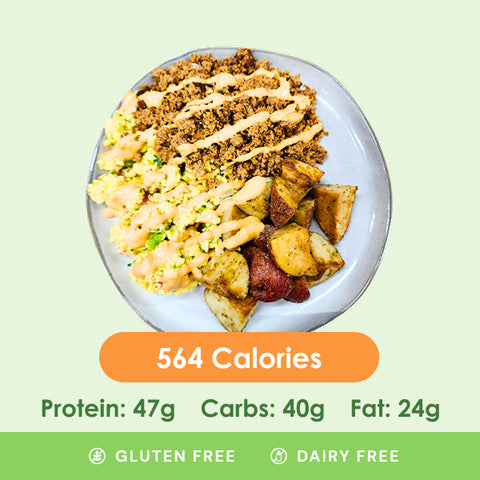 A hearty breakfast bowl featuring fluffy scrambled eggs, savory ground meat drizzled with sauce, and perfectly roasted potatoes.