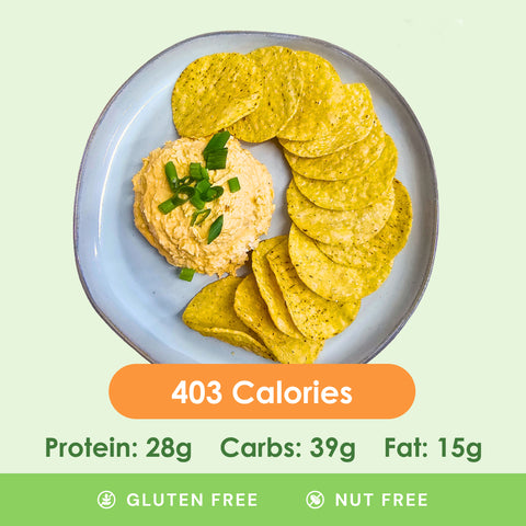 A bubbling hot and cheesy buffalo chicken dip, garnished with fresh green onions, accompanied by crisp celery sticks for a healthy scoop.