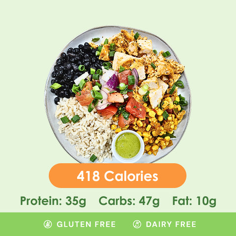 A vibrant chicken burrito bowl featuring tender chicken, black beans, fluffy rice, fresh pico de gallo, and a creamy green sauce.