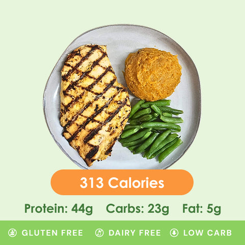 A perfectly grilled chicken breast with a savory Dijon sauce, served alongside vibrant green beans and a scoop of sweet potato mash.