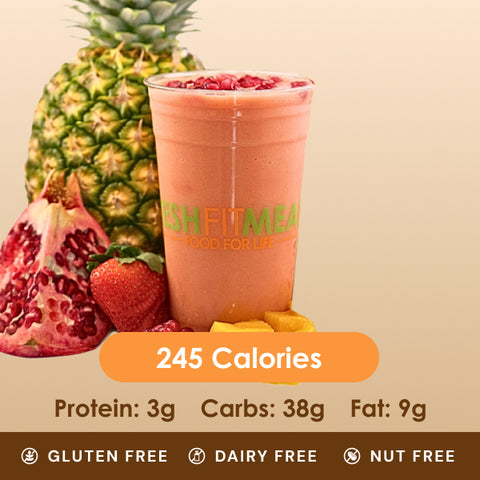 A vibrant pink smoothie with pomegranate seeds, next to pineapple and a strawberry.
