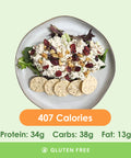 A fresh and flavorful chicken salad, generously studded with dried cranberries and walnuts, served with a side of savory crackers.