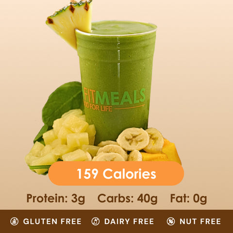 A vibrant green smoothie in a clear cup, with a pineapple slice, banana slices, and mango chunks, displaying its gluten-free, dairy-free, and nut-free status.