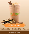 A tempting s'mores shake topped with toasted marshmallow and chocolate pieces, with crumbled graham crackers scattered around.