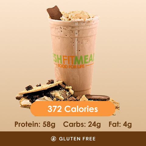 A tempting s'mores shake topped with toasted marshmallow and chocolate pieces, with crumbled graham crackers scattered around.