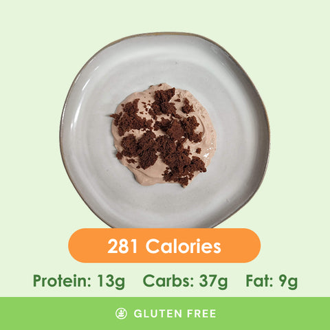 A delightful, light brown, creamy dessert topped with rich, dark chocolate crumbles, presented on a white plate.